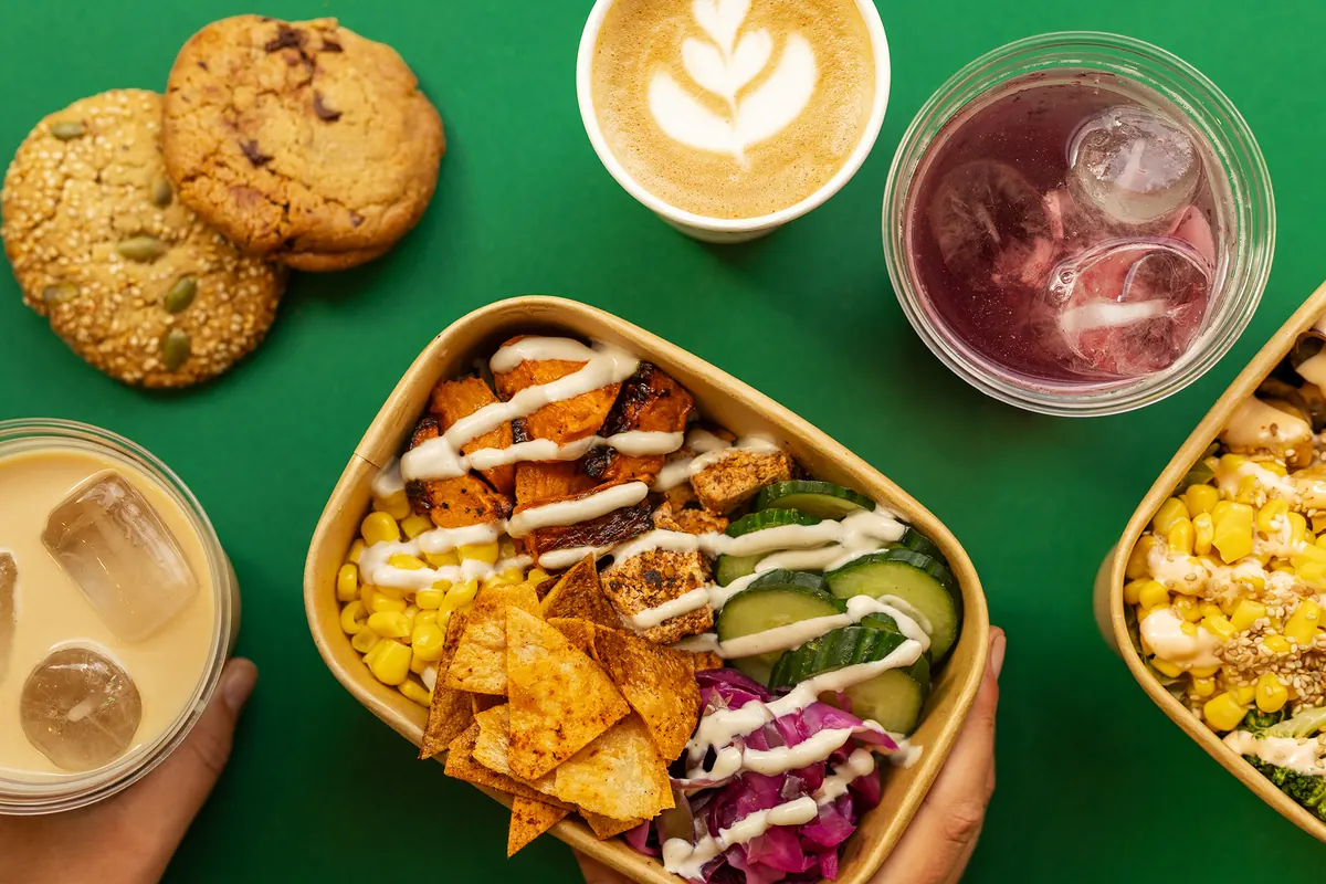 Een bowl met koffie, limonade en koekjes op groen