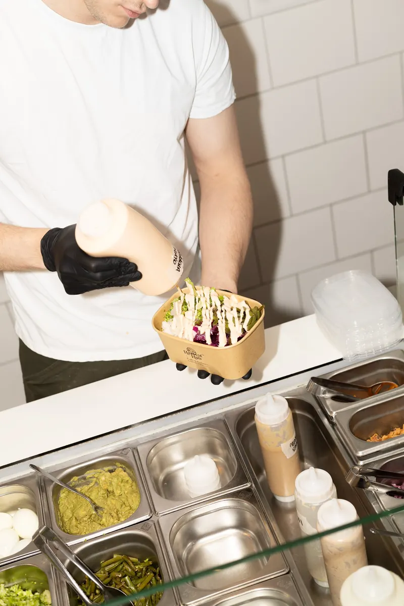 Saus gaat over een verse bowl aan de toonbank